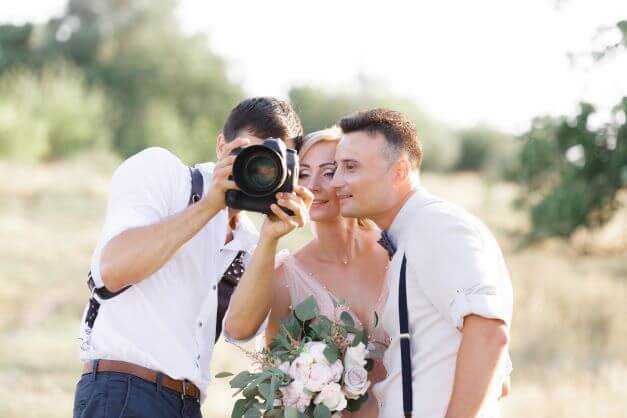 wedding photographer shows couple camera