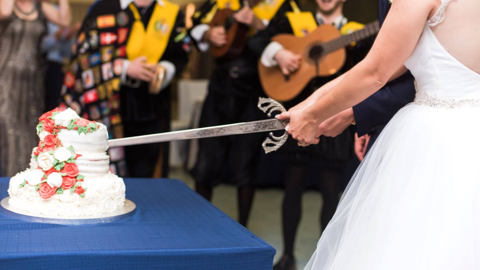 https://www.myidealwedding.co.uk/wp-content/uploads/2021/09/Spanish-Bride-Cuts-cake-with-a-sword.jpeg