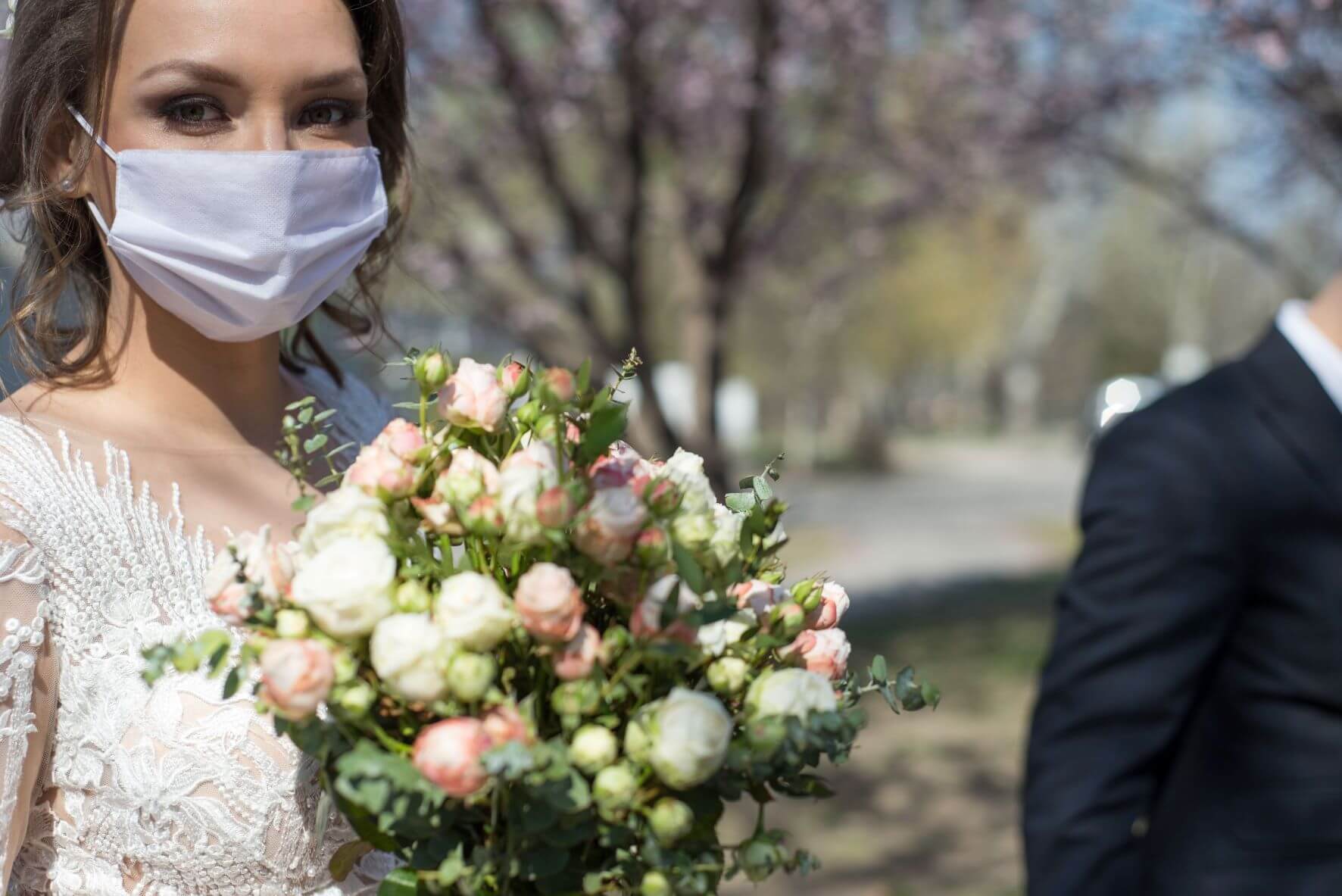 bride adheres to covid restrictions at weddings by wearing a mask