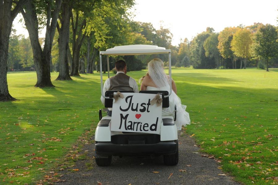 bride and groom in a golf cart